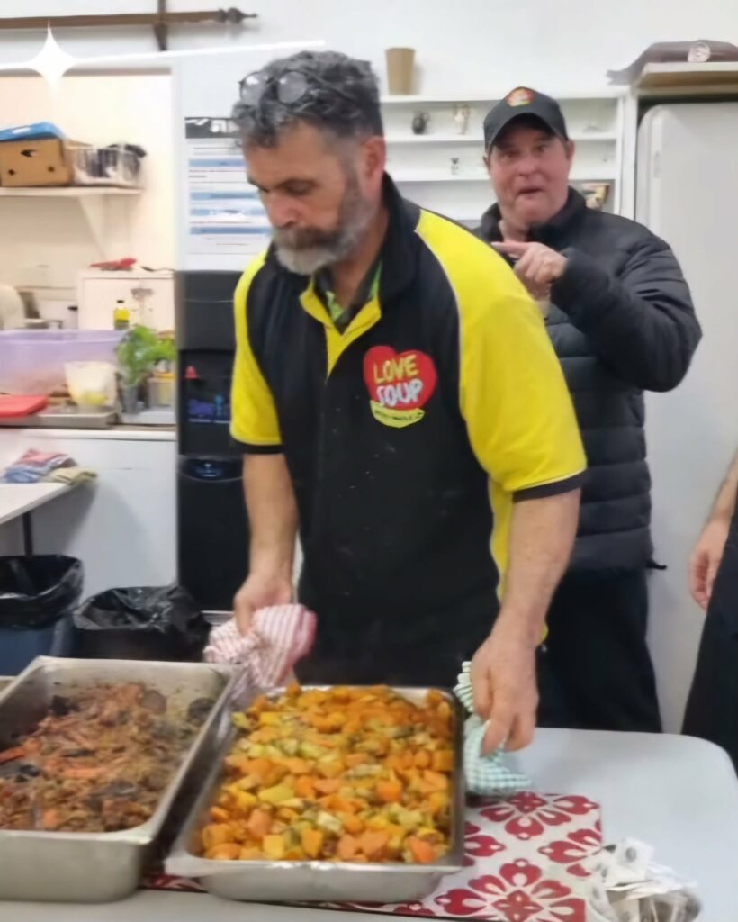 Volunteers serving hot roast vegetables at a Love Soup community dinner