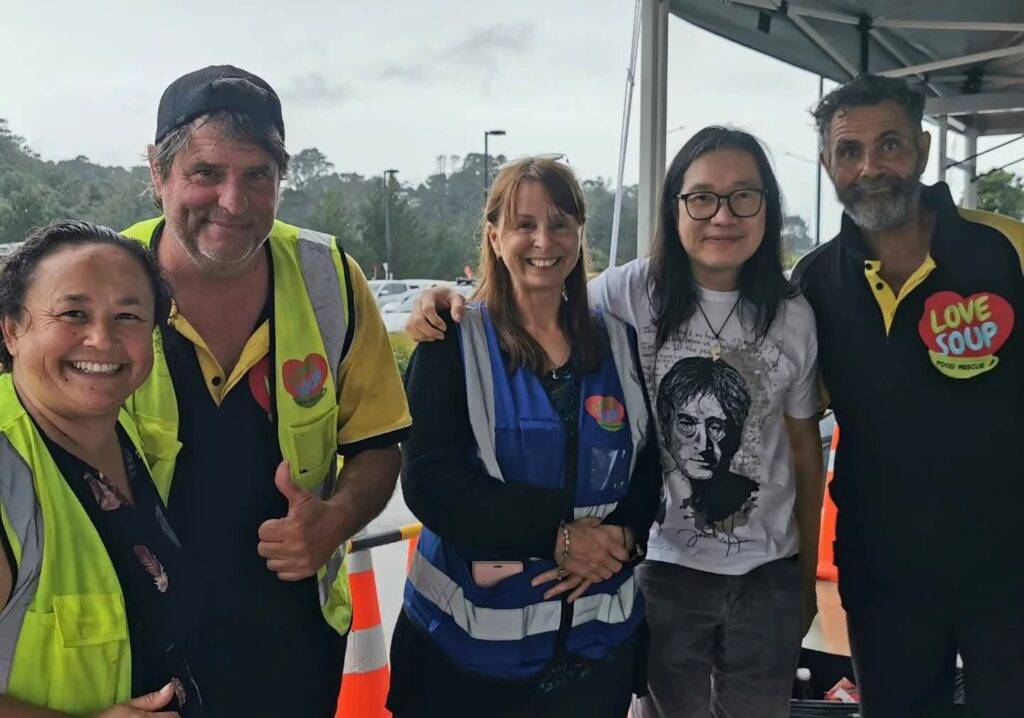 A smiling team of Love Soup volunteers in hi vis vests